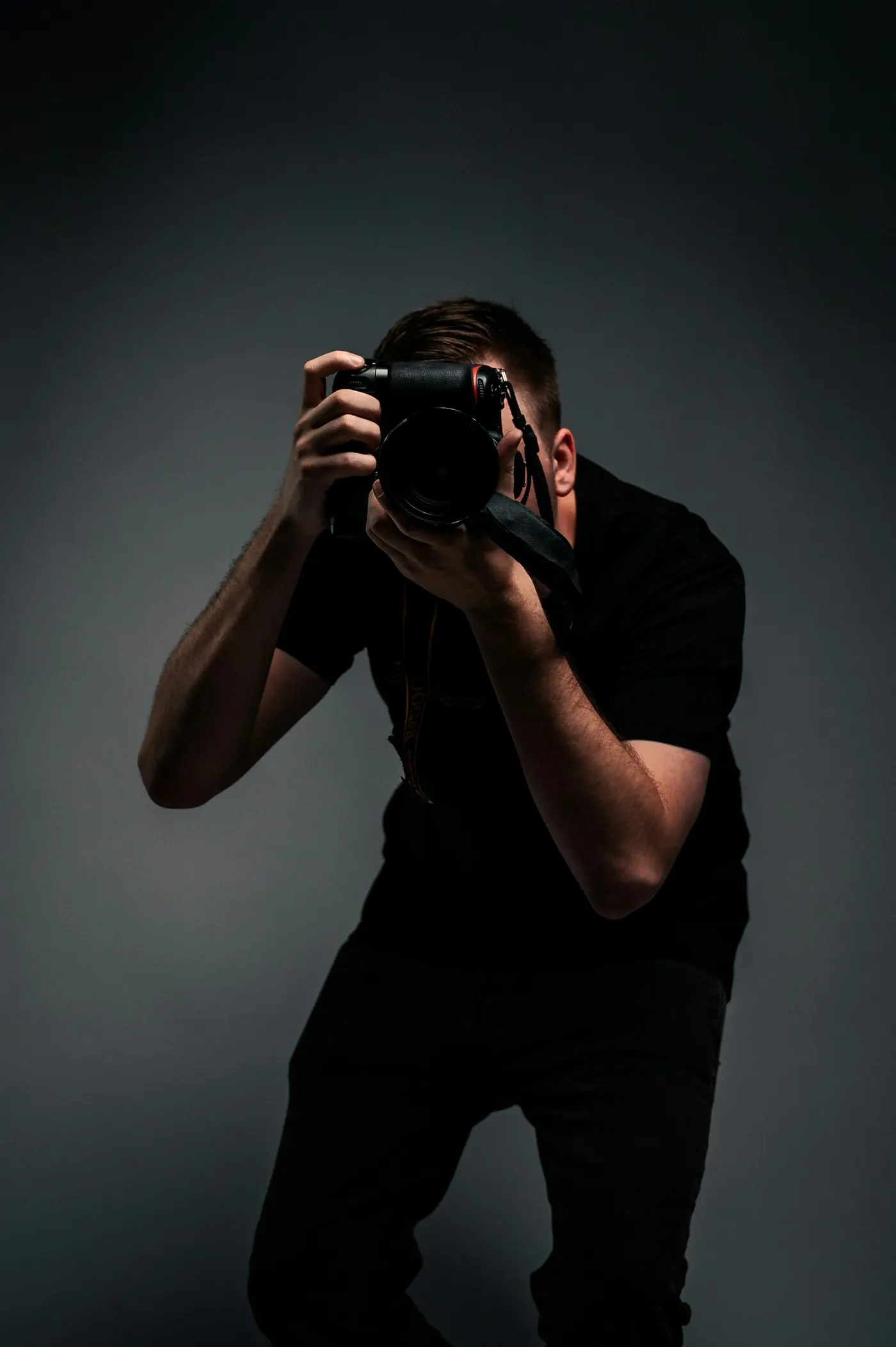 Fotograf s digitálnou zrkadlovkou pri práci v teréne